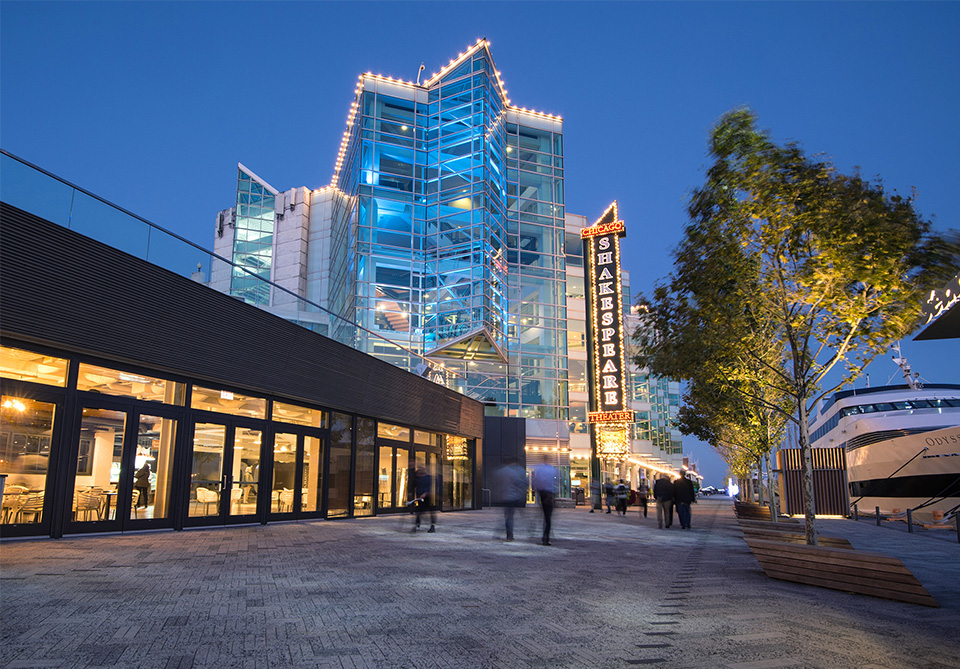 Exterior of Chicago Shakespeare Theater at night lit up on Navy Pier. 