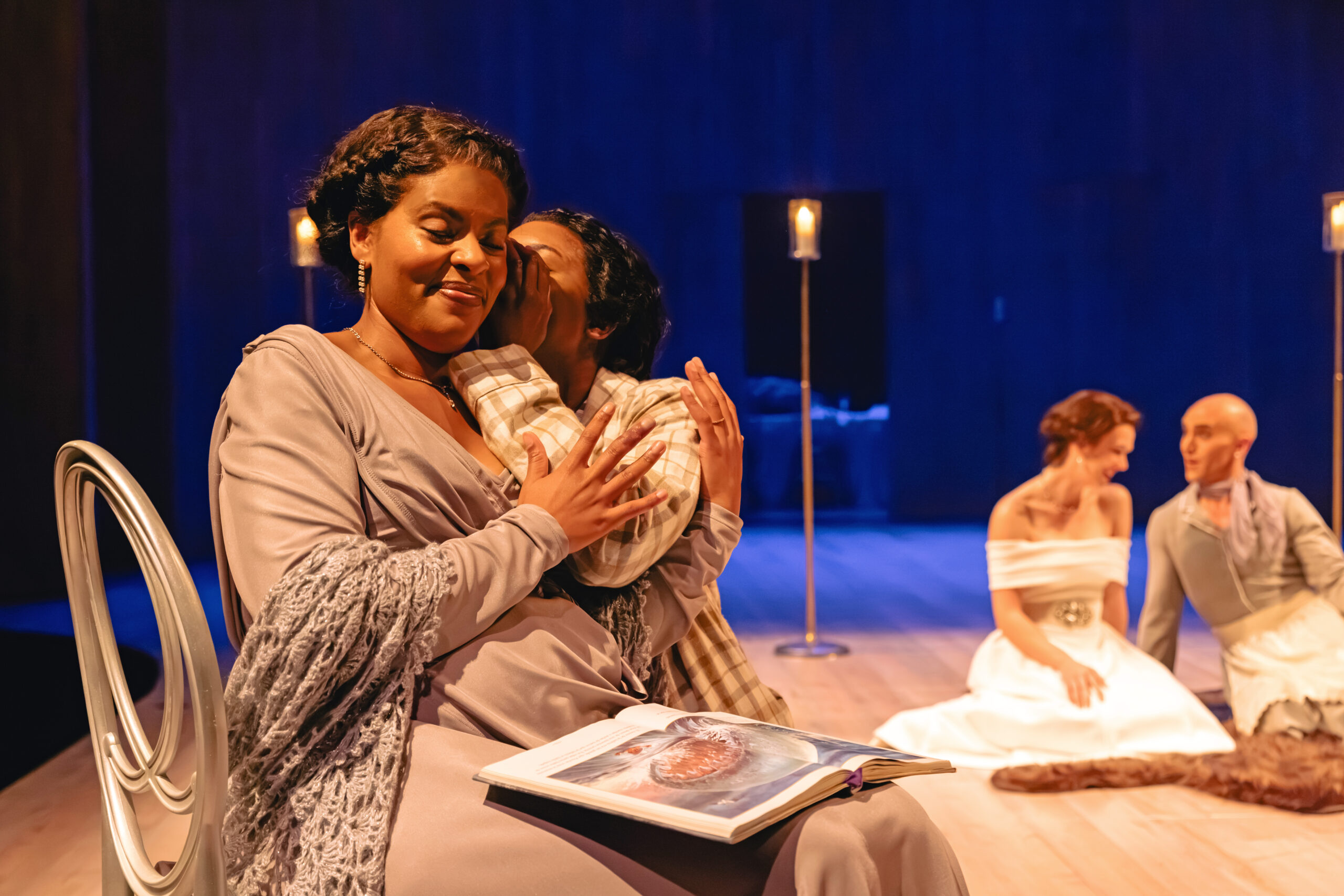   Felicia Oduh as Mamillius whispers into Jessica Dean Turner as Hermione's ear
